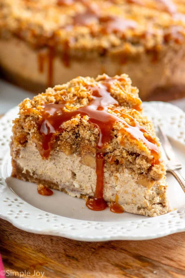 Slice of Caramel Apple Cheesecake garnished with caramel served on a plate with a fork