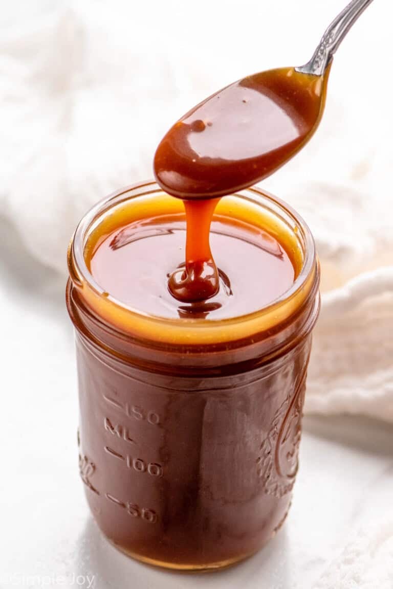 Photo of a jar of caramel sauce with a spoon scooping some out
