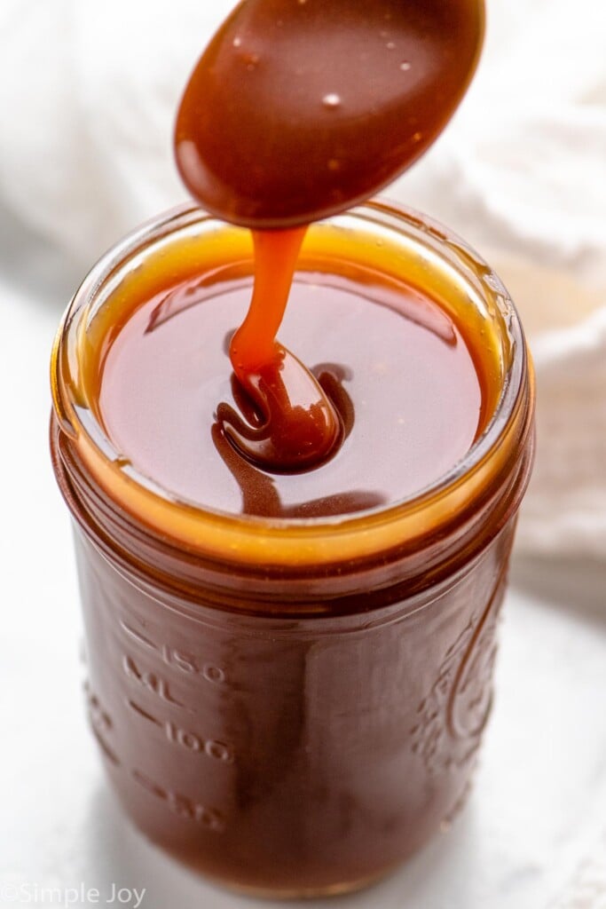 Jar of caramel sauce with a spoon scooping some out - 4