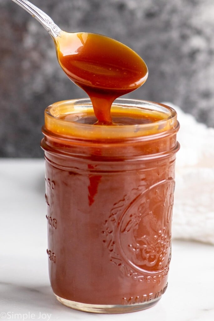 Side view of a jar of caramel sauce with a spoon - 12