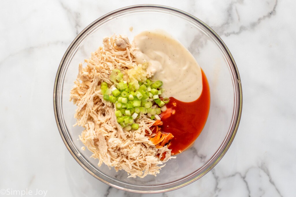 Overhead view of a mixing bowl of filling ingredients for Buffalo Chicken Sliders recipe. - 6
