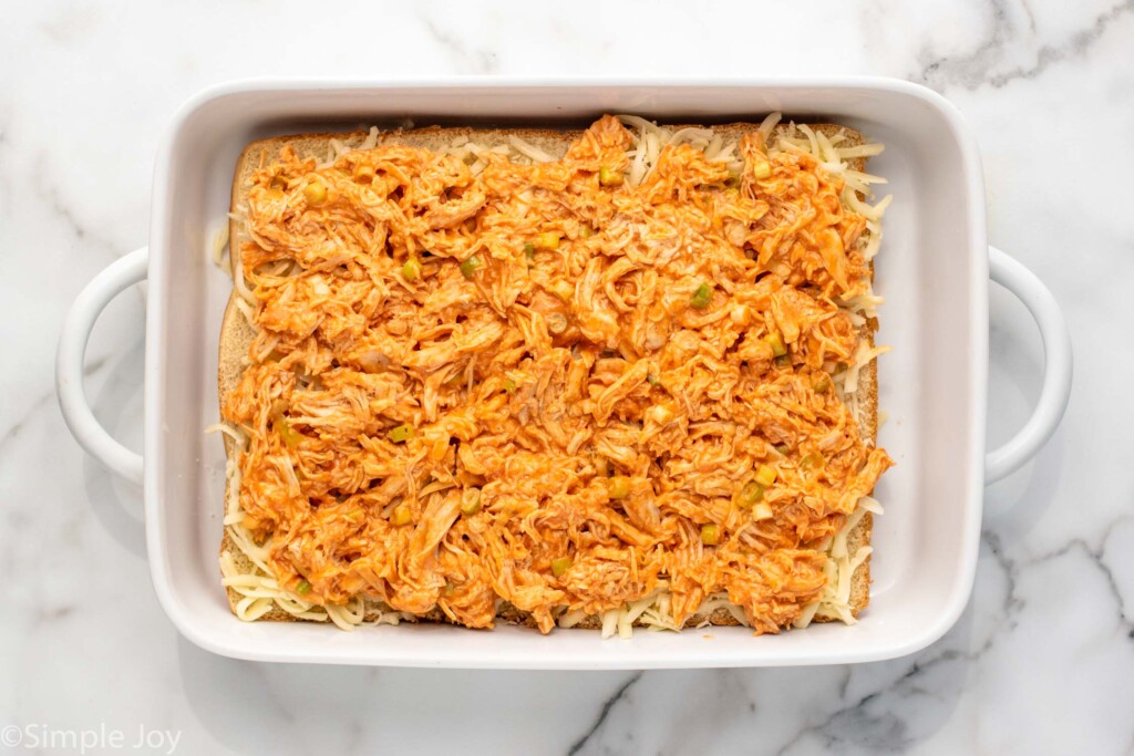 Overhead view of layers of Buffalo Chicken Sliders before baking.