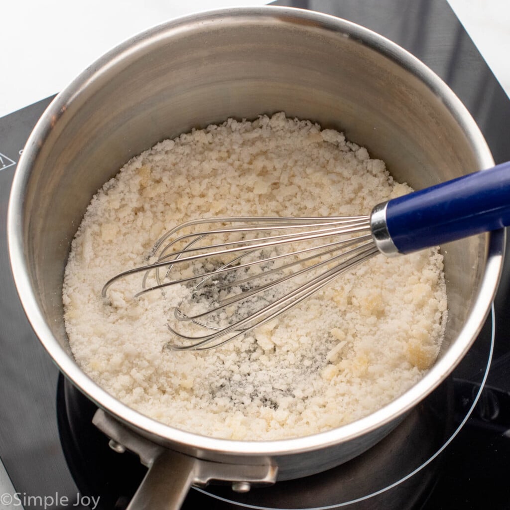 Overhead view of a pot with sugar and a whisk for caramel sauce recipe
