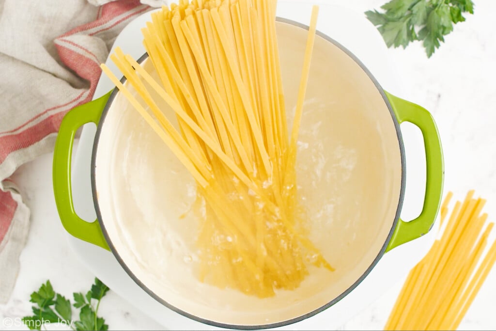 overhead of large pot of boiling water with fettuccine pasta inside to make fettuccine alfredo recipe - 4