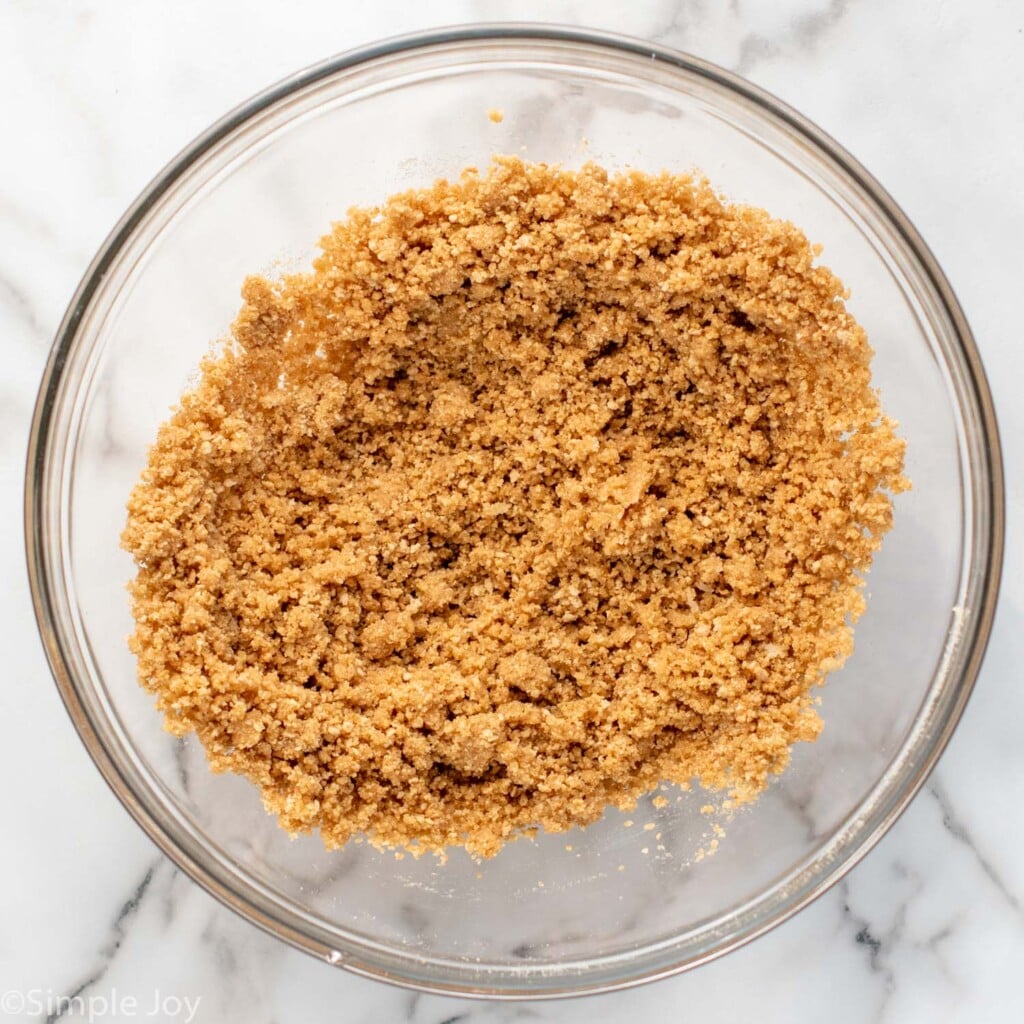 Overhead view of a mixing bowl of No Bake Cheesecake crust ingredients.