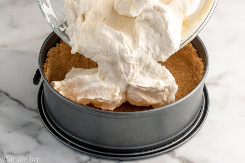Mixing bowl of filling being poured into crust for No Bake Cheesecake recipe - 11