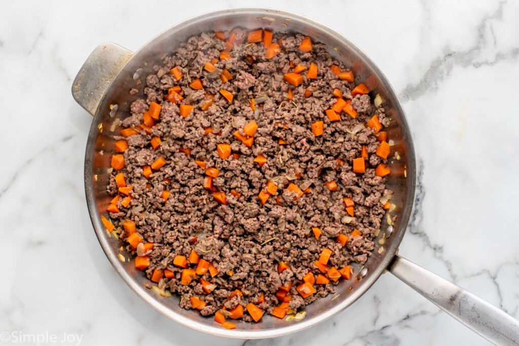 Overhead view of a skillet of hamburger and carrots for Shepherd's Pie recipe. - 6
