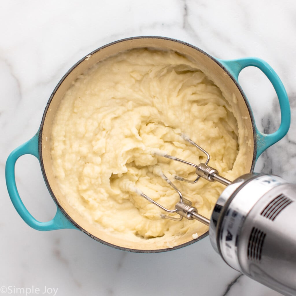 Overhead view of a pot of mashed potatoes with a beaters for Shepherd's Pie recipe.