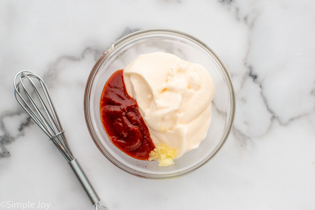 Overhead view of mixing bowl of ingredients for sriracha mayo with whisk beside for Sushi Bowl recipe - 6