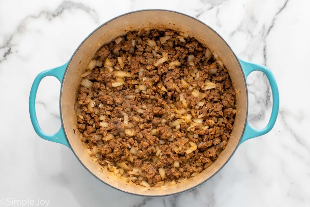 Overhead view of a pot of meat and onions cooking for Zuppa Toscana recipe - 7
