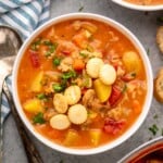 Overhead view of a bowl of Manhattan Clam Chowder with a spoon beside - 13