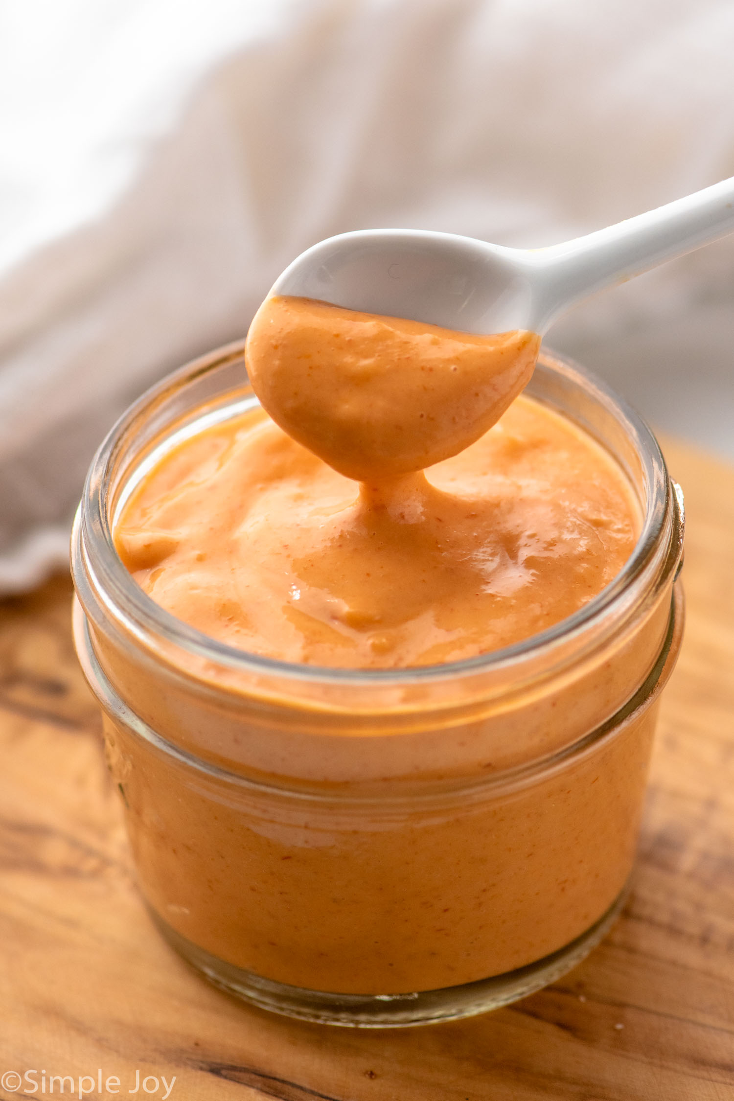Jar of Sriracha Mayo with a small spoon