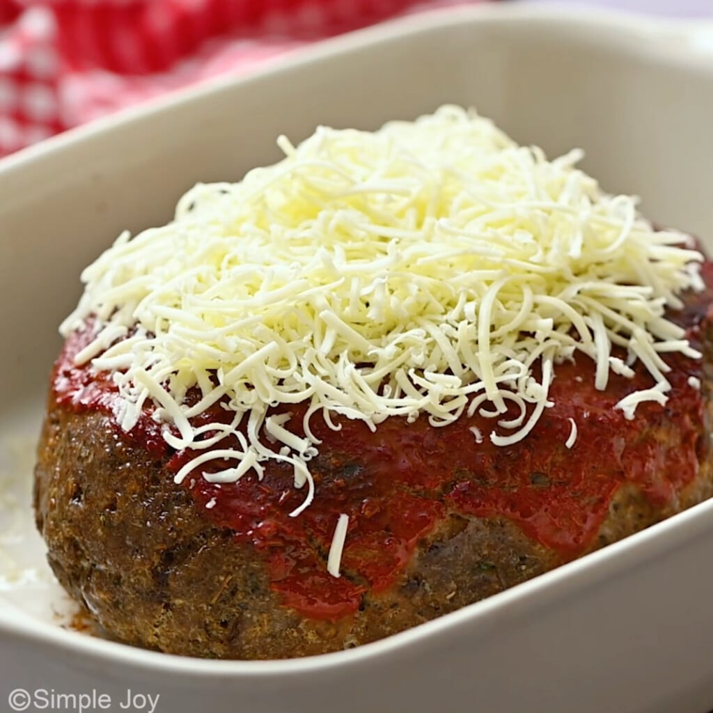 partially baked italian meatloaf, with cheese layered on top