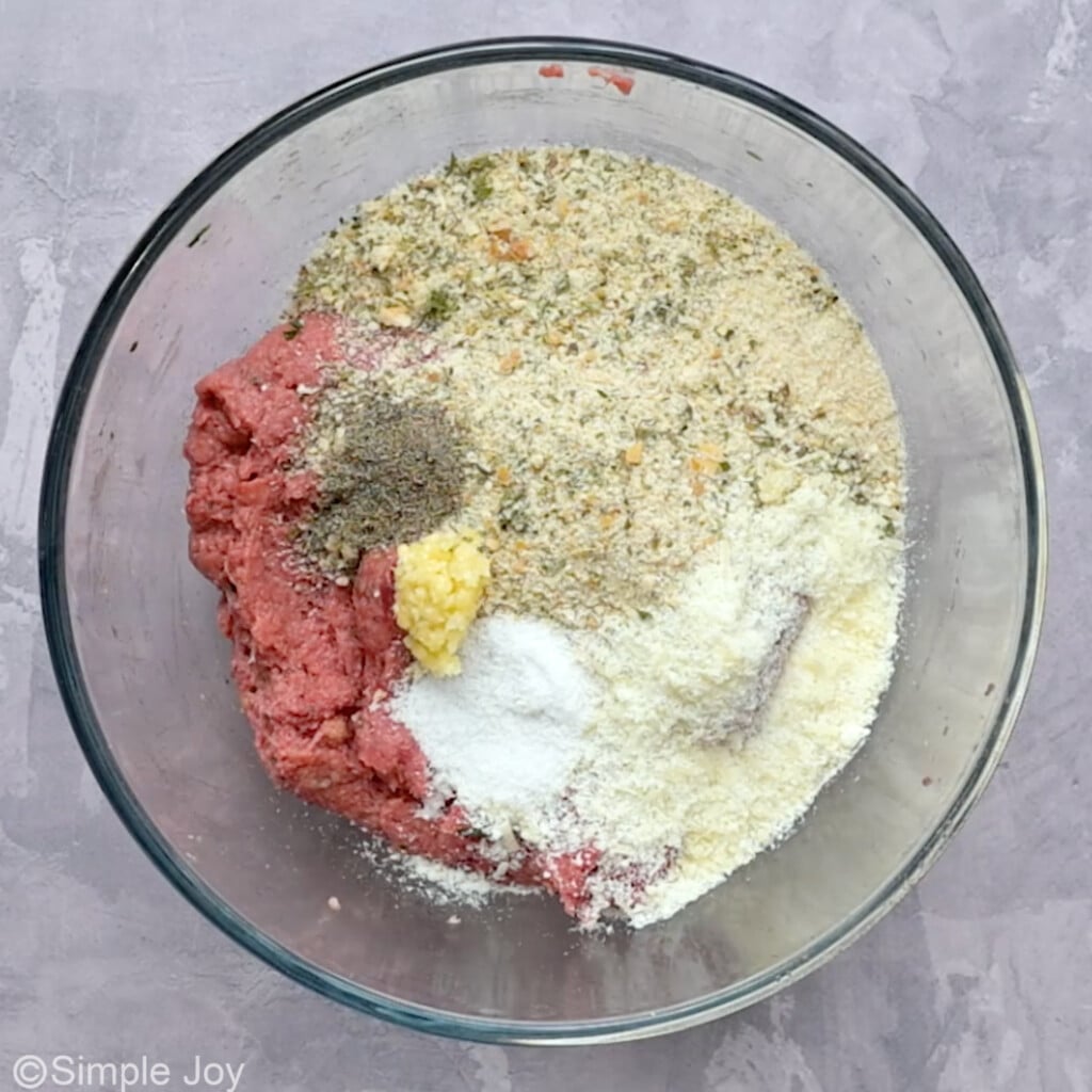 meat with breadcrumbs, cheese, and spices to make Italian meatloaf