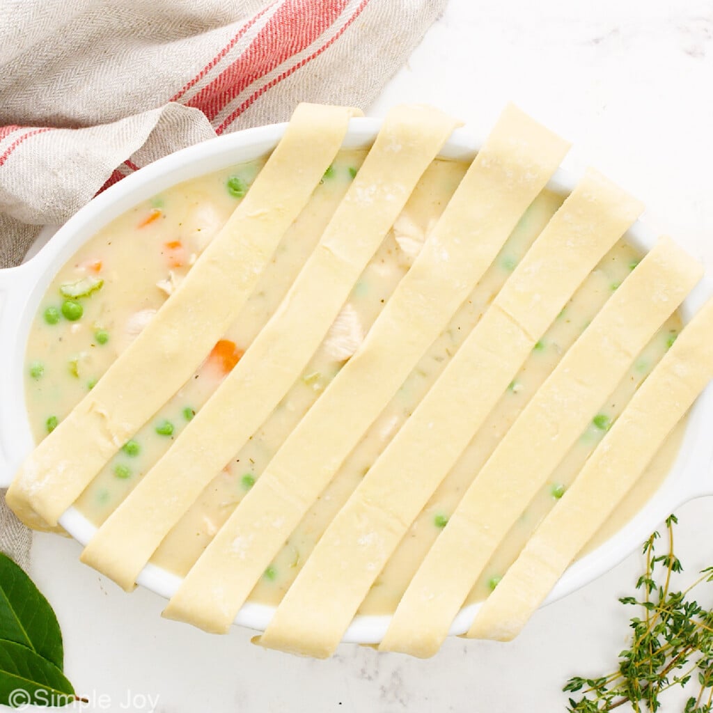 adding strips of puff pastry to the top of a chicken pot pie casserole