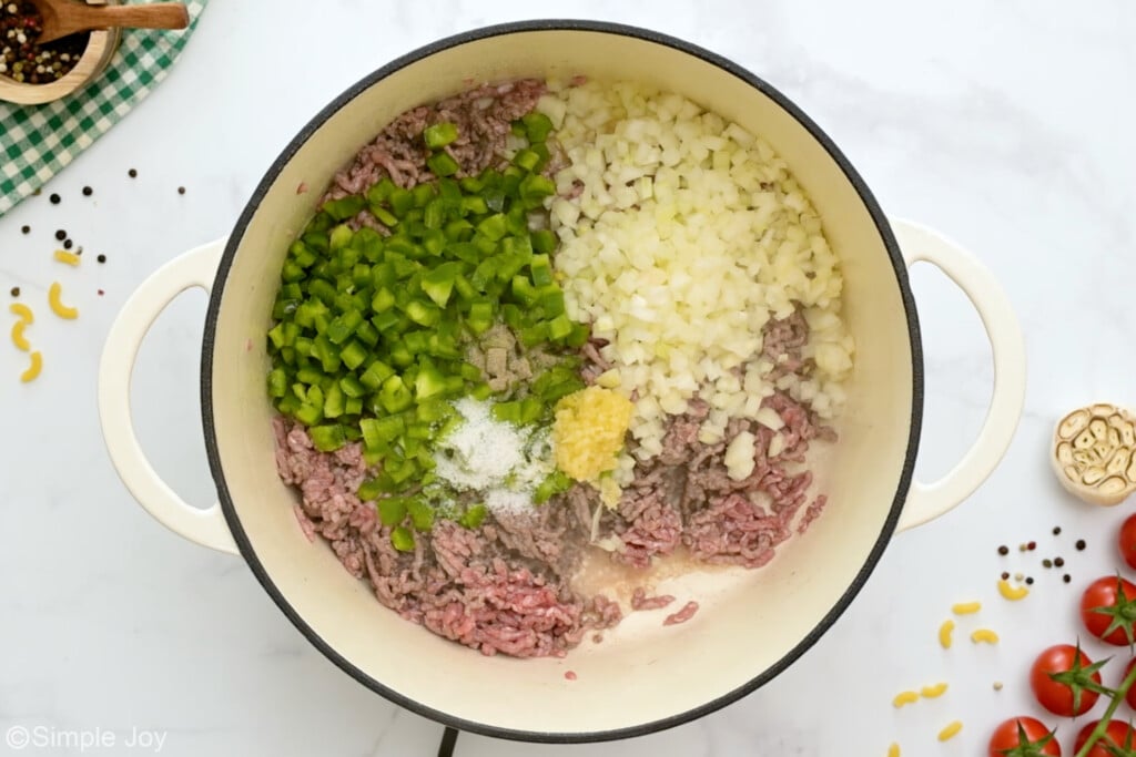 overhead of a large bot with ground beef, onion, garlic, green bell pepper, and garlic cooking - 6