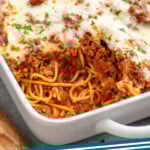 Pinterest graphic for Baked Spaghetti recipe. Image shows baking dish of Baked Spaghetti recipe with piece missing. Text says, "Baked Spaghetti simplejoy.com."