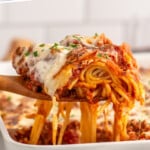 Pinterest graphic for Baked Spaghetti recipe. Text says, "the best Baked Spaghetti simplejoy.com." Image shows side view of spoon lifting up piece of Baked Spaghetti from baking dish of Baked Spaghetti recipe.