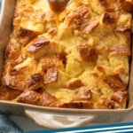 Pinterest graphic for Bread Pudding recipe. Image shows a baking dish of Bread Pudding with sauce being poured over top. Text says, "bread pudding simplejoy.com."