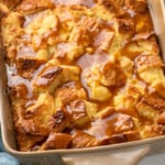 Pinterest graphic for Bread Pudding recipe. Image shows a baking dish of Bread Pudding with sauce on top. Text says, "super easy Bread Pudding simplejoy.com."