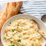 Pinterest graphic for chicken gnocchi soup recipe. Text says, "the best chicken gnocchi soup simplejoy.com." Image shows a bowl of chicken gnocchi soup with a spoon. Bread beside.