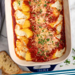 Pinterest graphic for Cheese manicotti recipe. Image shows overhead view of a baking dish of Cheese manicotti with bread beside. Text says, "Manicotti recipe simplejoy.com."