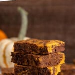 Pinterest graphic for Pumpkin brownies recipe. Text says, "the best Pumpkin brownies simplejoy.com." Image shows a side view of a stack of Pumpkin brownies.