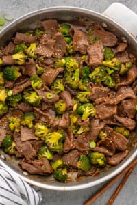 Overhead view of a skillet of easy Beef and Broccoli with sesame seeds and chopped green onions