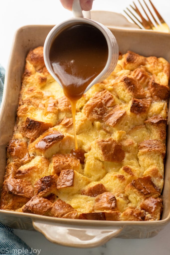 Baking dish of Bread Pudding with sauce being poured over top. - 12