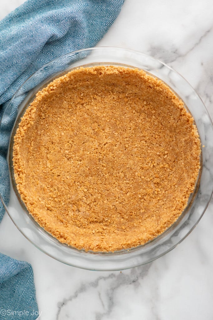 Overhead view of a graham cracker crust in a pie plate - 9