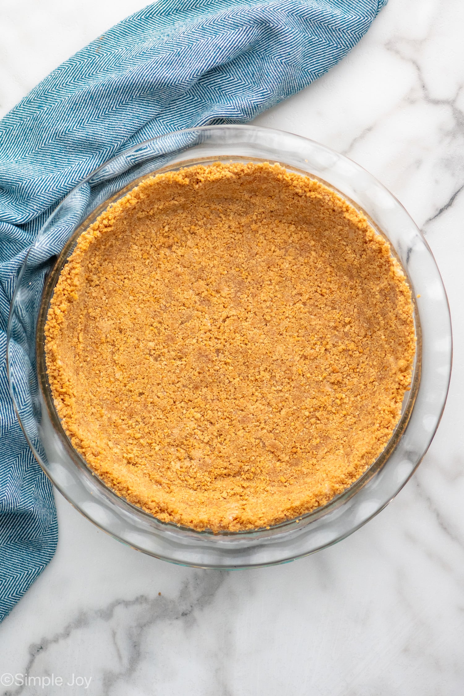 Overhead view of graham cracker crust in a pie plate