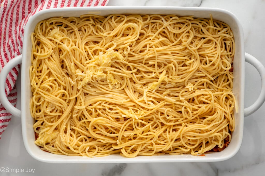 Overhead view of a baking dish with spaghetti and cheese for Baked Spaghetti recipe.