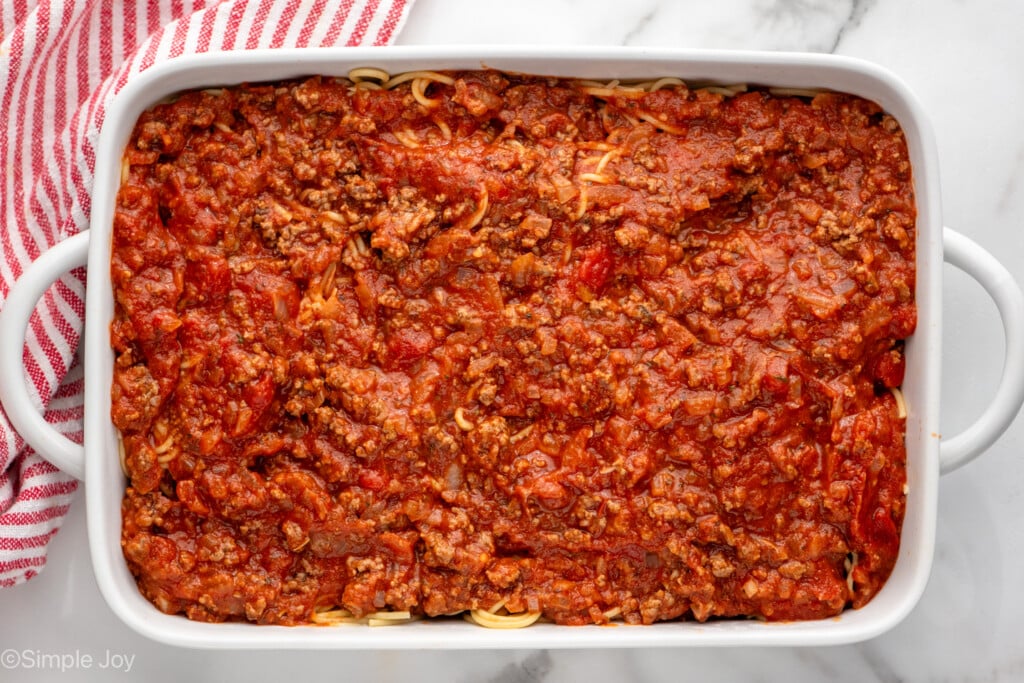 Overhead view of a baking dish of Baked Spaghetti recipe with sauce on top before baking.
