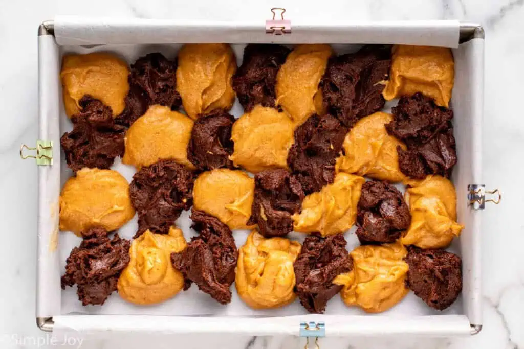 Overhead view of batter dropped into baking dish for Pumpkin brownies recipe.