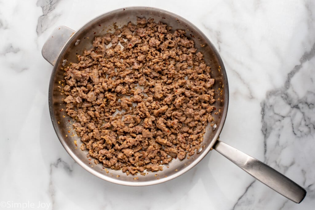 Overhead view of a skillet of cooked ground sausage for Sausage Broccoli Pasta recipe. - 7