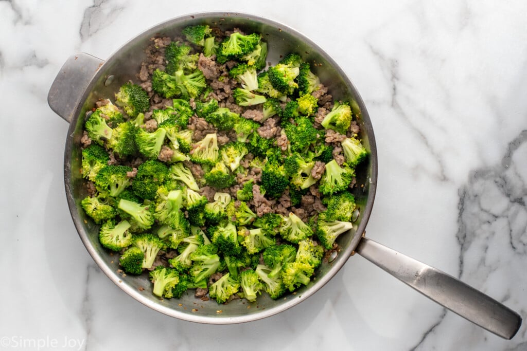 Overhead view of a skillet of sausage and broccoli for Sausage Broccoli Pasta recipe. - 8