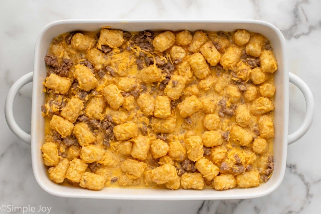Overhead view of a baking dish of tater tot breakfast casserole recipe before baking.