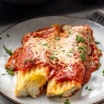 Cheese manicotti served on plate garnished with parsley flakes - 12