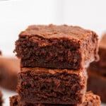 Pinterest graphic for Fudgy Brownie Recipe. Text says, "the best brownie recipe simplejoy.com." Image shows side view of stack of fudgy brownies.