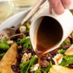 Pinterest graphic for Pear Salad recipe. Text says, "the best Pear Salad recipe simplejoy.com." Image shows person's hand pouring dressing over bowl of Pear Salad with forks.