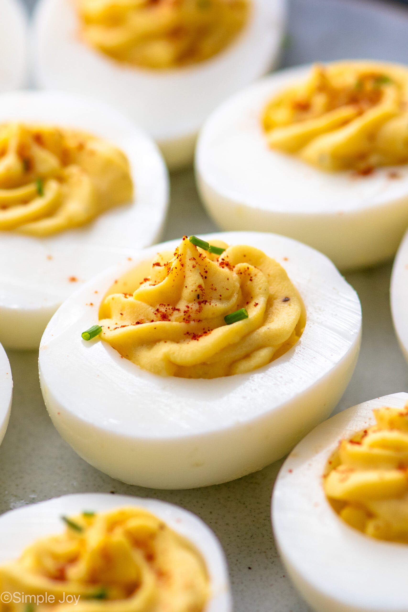 Close up of Deviled Eggs garnished with paprika and chopped chives