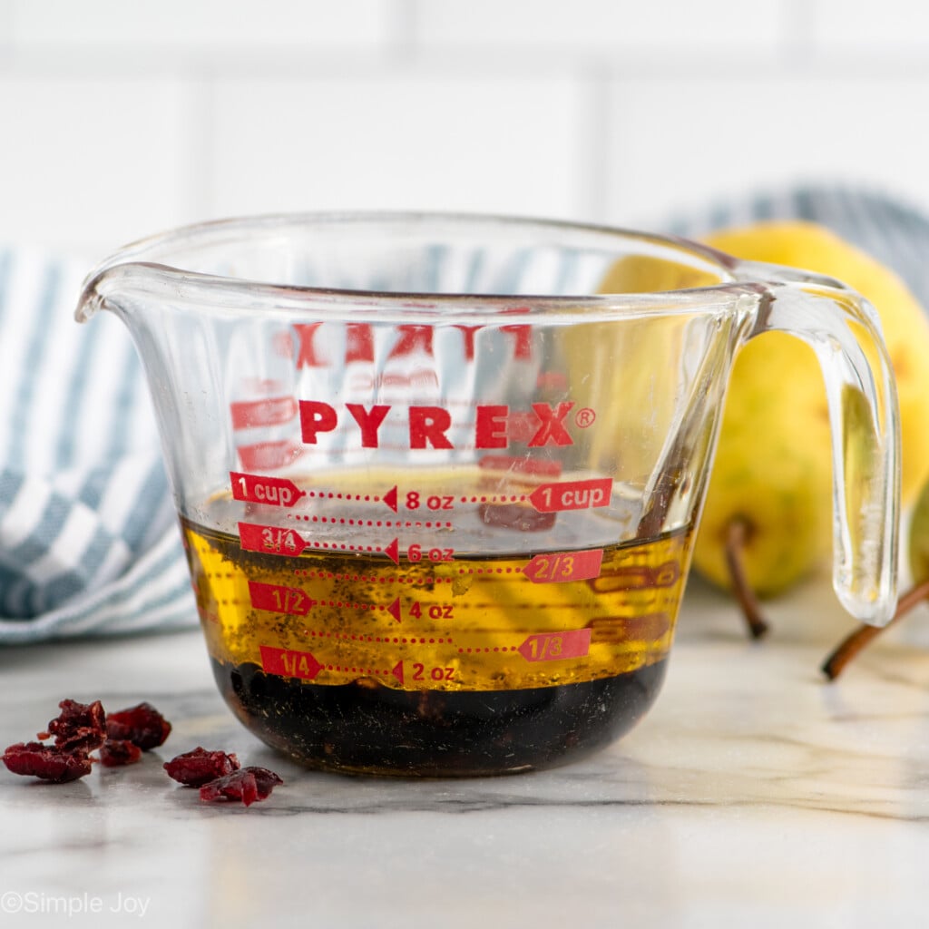 Side view of glass measuring cup of ingredients for Pear Salad dressing. - 7