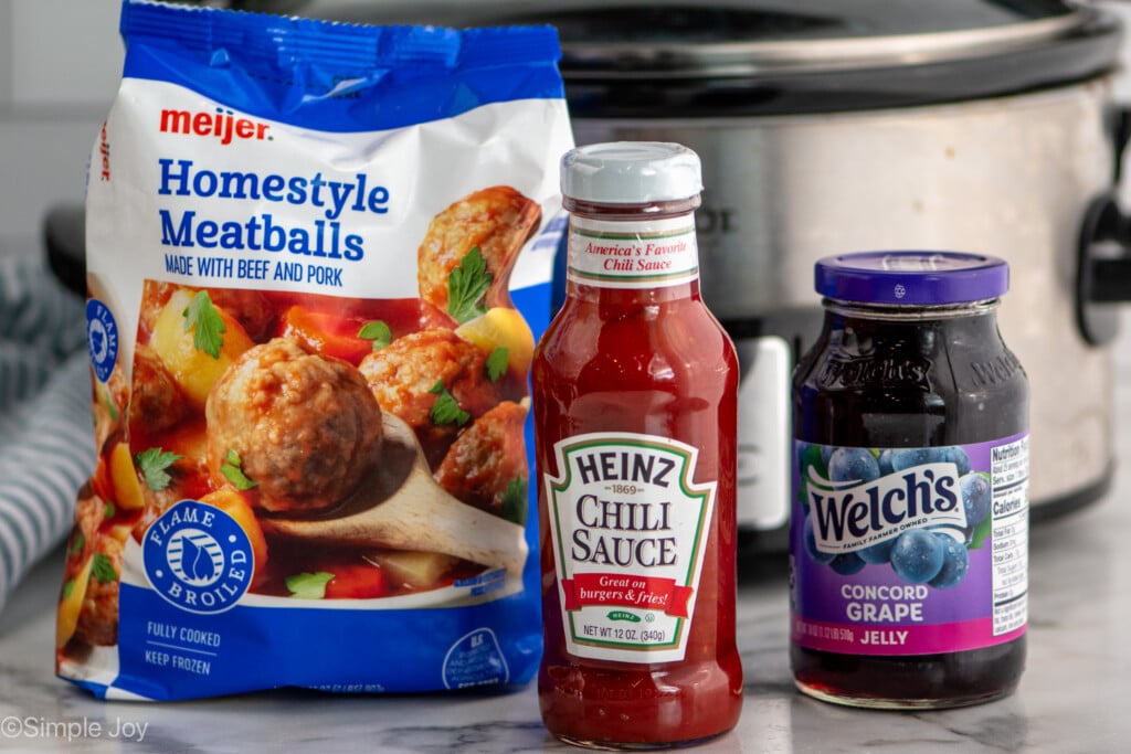 Side view of three ingredients for Grape Jelly Meatballs recipe with crockpot behind. - 5