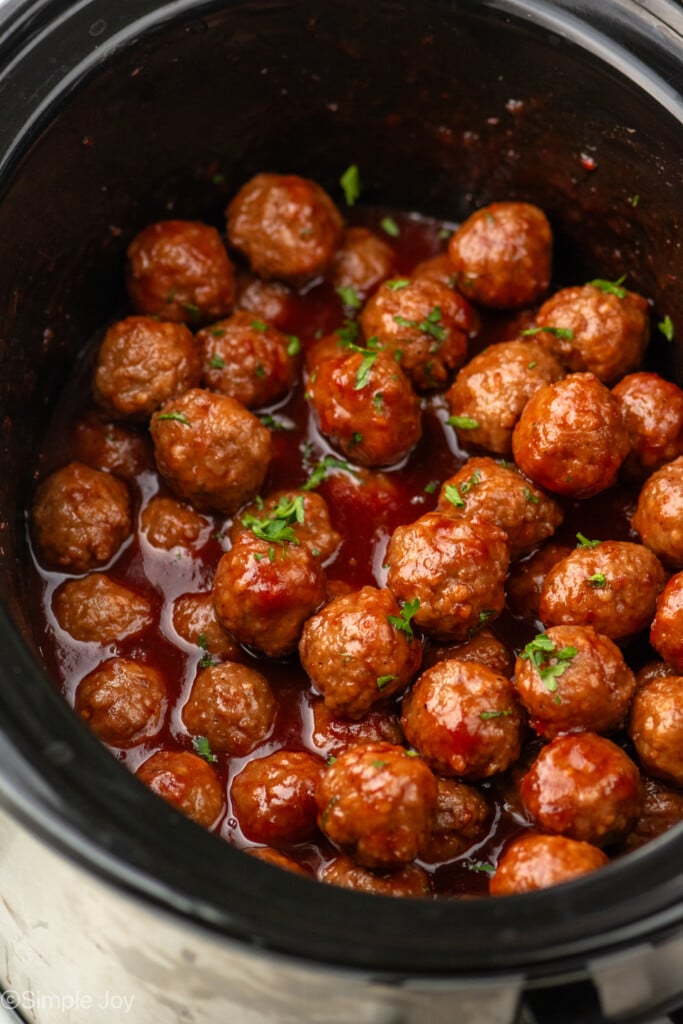 Crockpot of Grape Jelly Meatballs garnished with flakes of parsley - 4