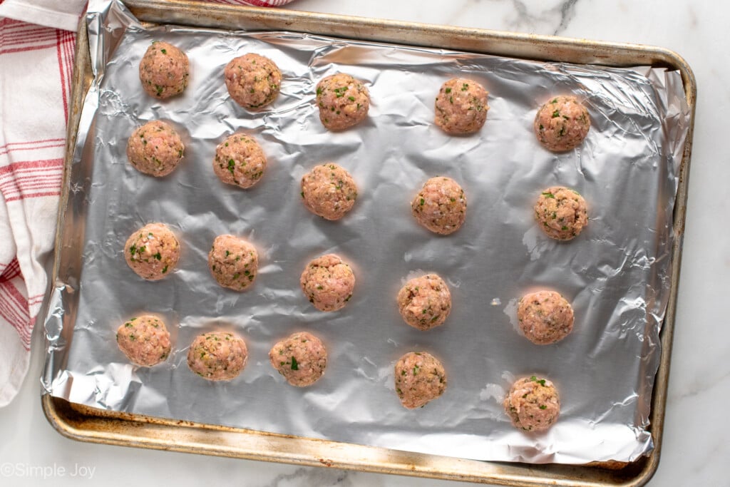 Overhead view of a foil-covered baking sheet with Baked Turkey Meatballs recipe before baking - 6