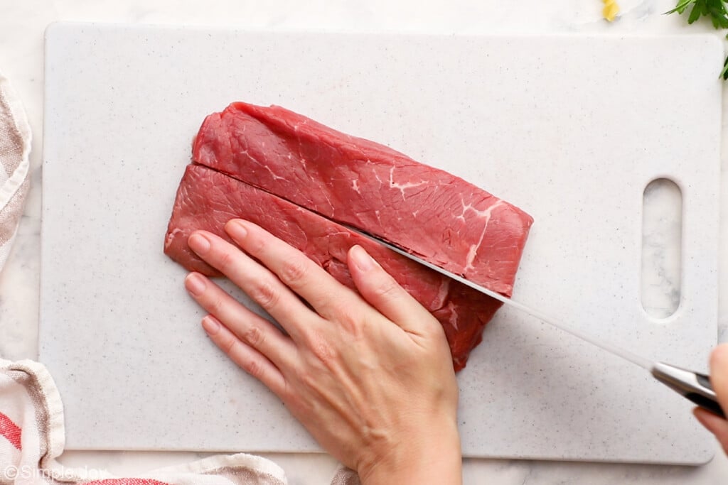 overhead photo of a piece of beef being cut in half