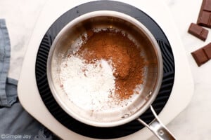 overhead of a saucepan with cornstarch, sugar, cocoa powder, and salt