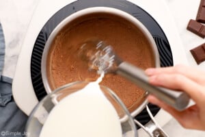 pouring milk into a sauce pan to make chocolate pudding