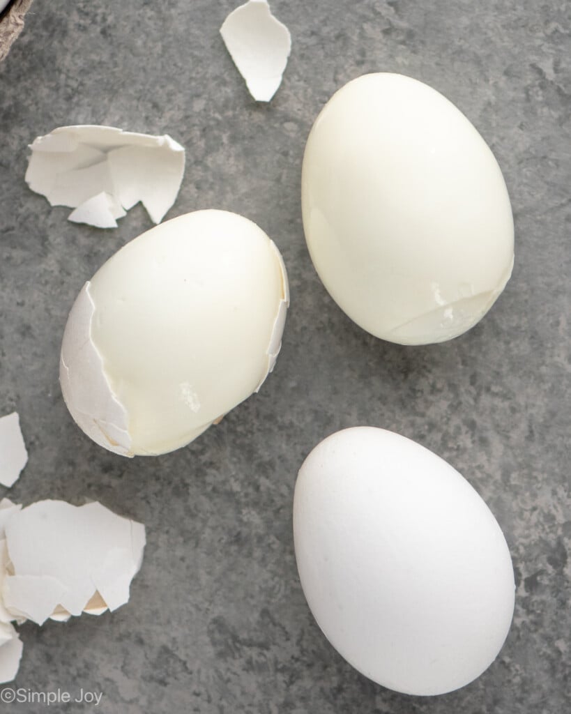Overhead view of hard boiled eggs partially peeled on counter top for Deviled Eggs recipe - 6