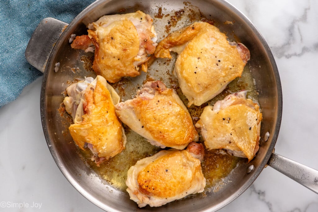 Overhead view of chicken thighs in a skillet for Honey Garlic Chicken Thighs recipe.